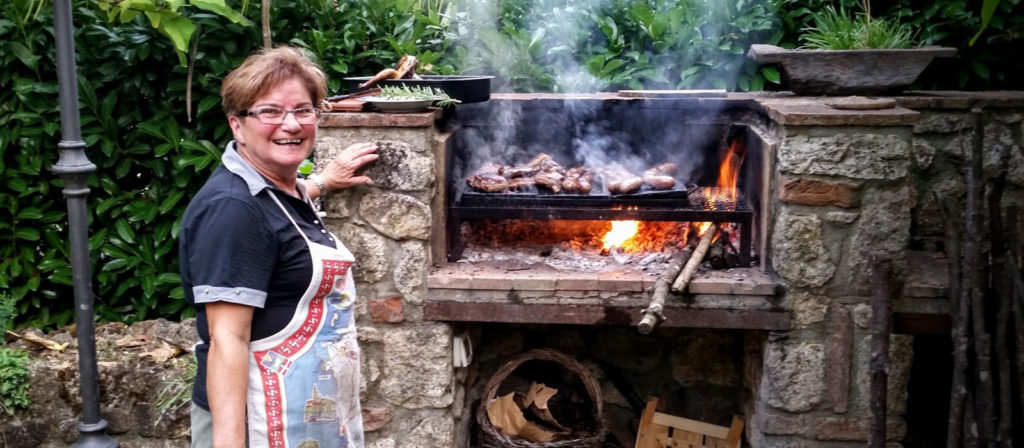 Grandma Lia cooking dinner for our riders. She cooks all of the meats over an open fire.